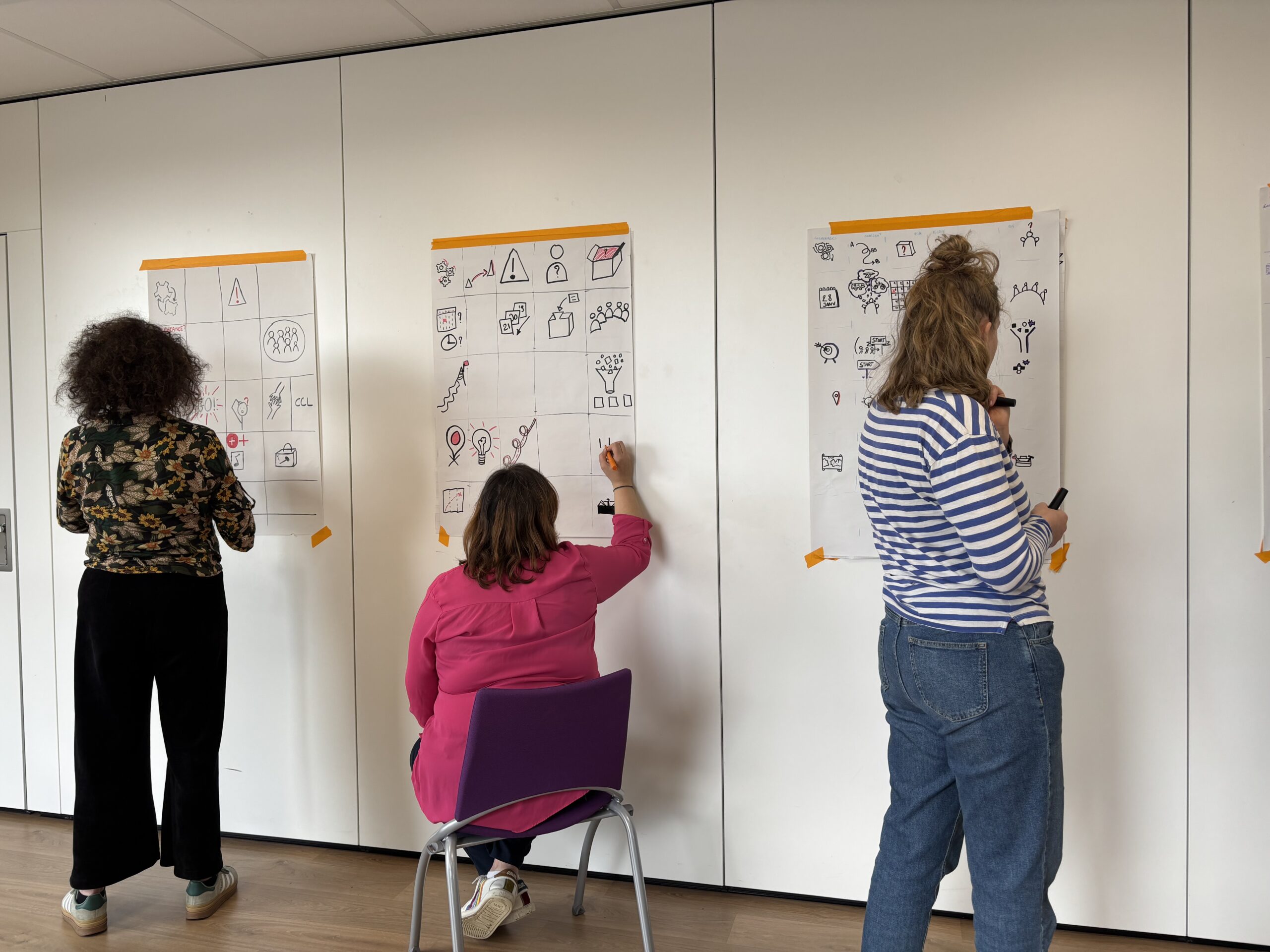 2025_FormationFG Trois personnes dessinent sur des grands panneaux verticaux